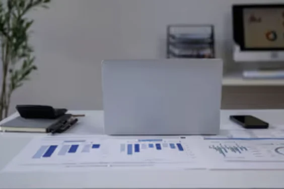 Budget charts on a desk beside a laptop