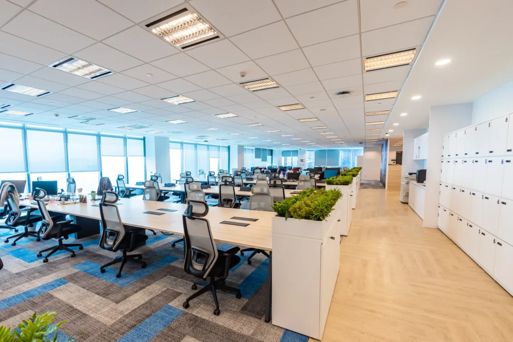Open-plan office with bench workstations, planter dividers and full-height lockers