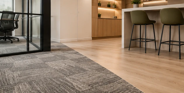 Carpet tiles in a work zone meeting timber-look vinyl plank in a pantry with bar stools