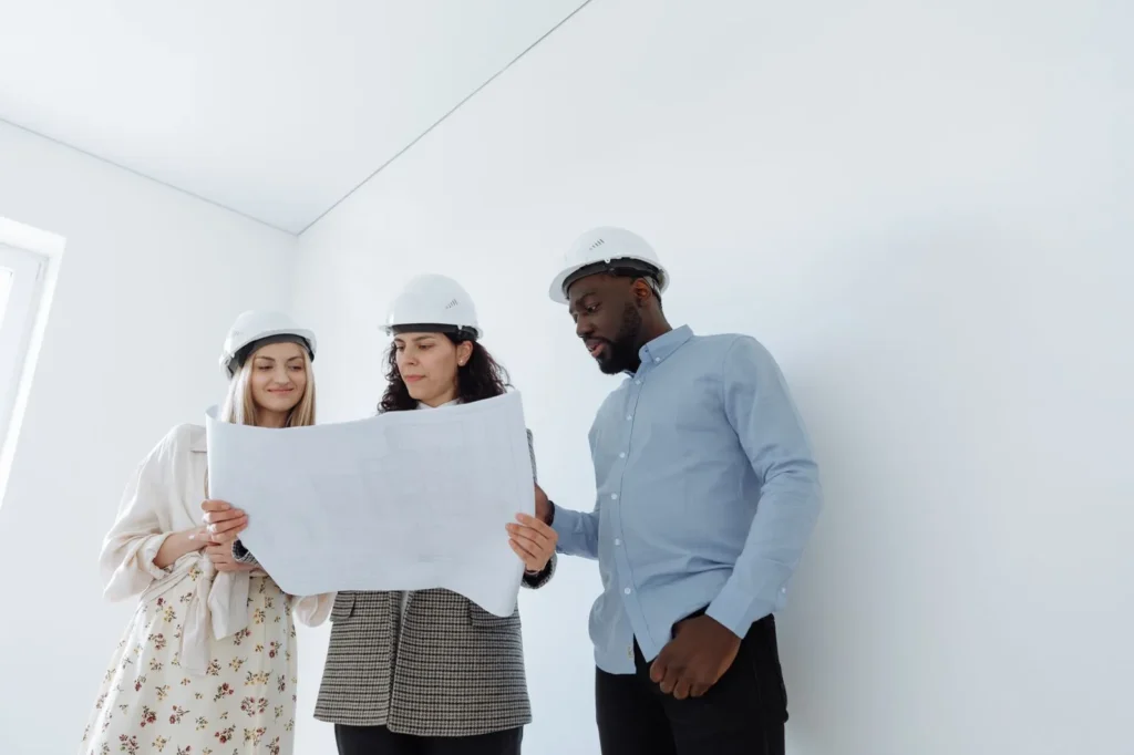Project team reviewing drawings on an empty office floor